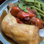 Poulet méditerranéen avec tomates et poivrons servi avec des haricots verts