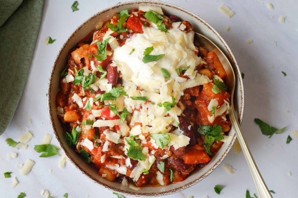 bol de chili au bœuf haché avec crème sure et fromage sur le dessus