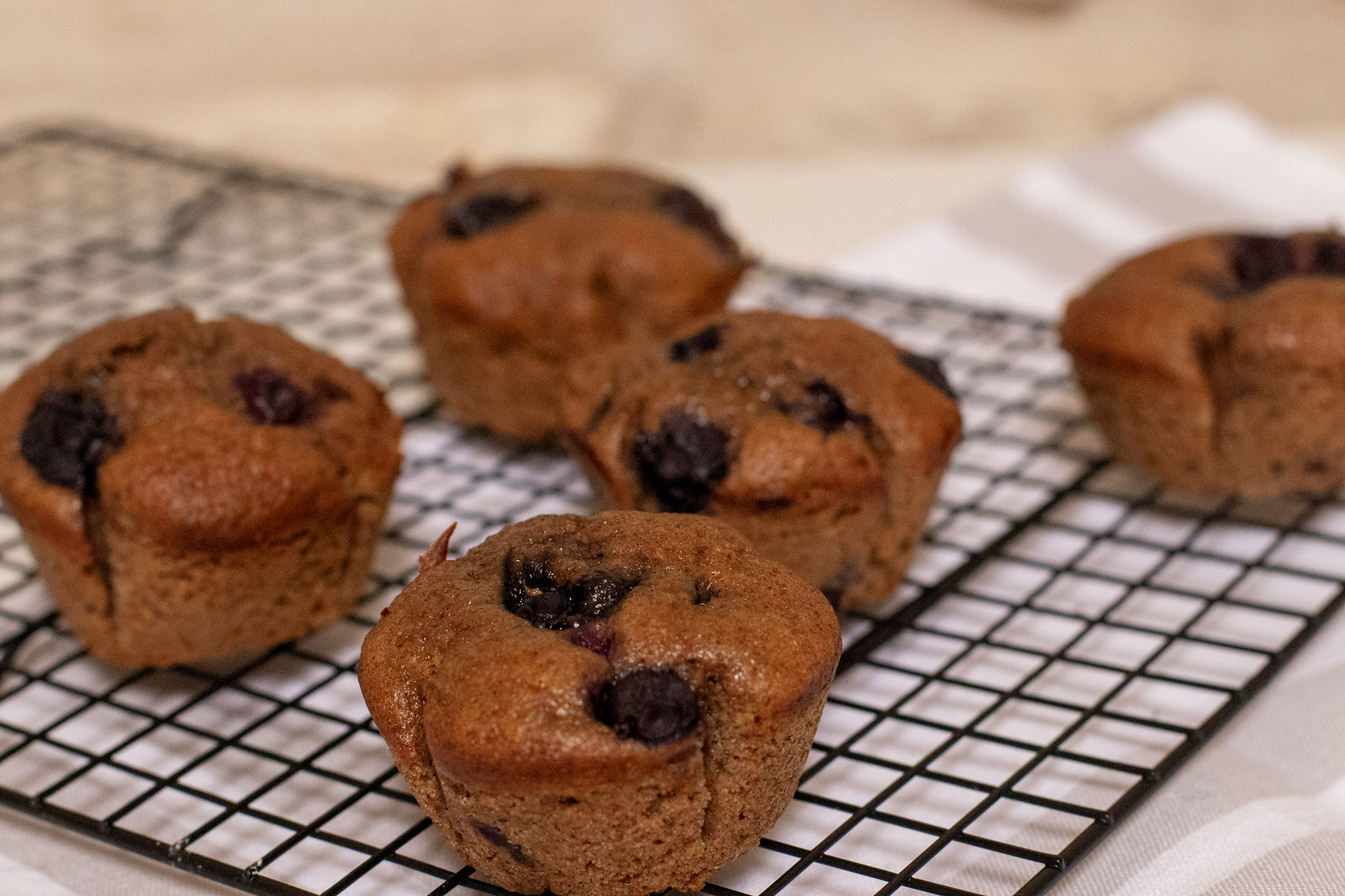 Dairy Free Whole Wheat Blueberry Muffins on a black wire rack