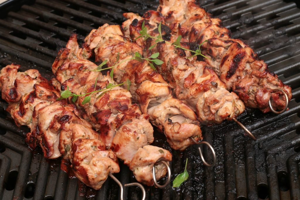 grilled chicken skewers marinated in lemon and garlic on a grill