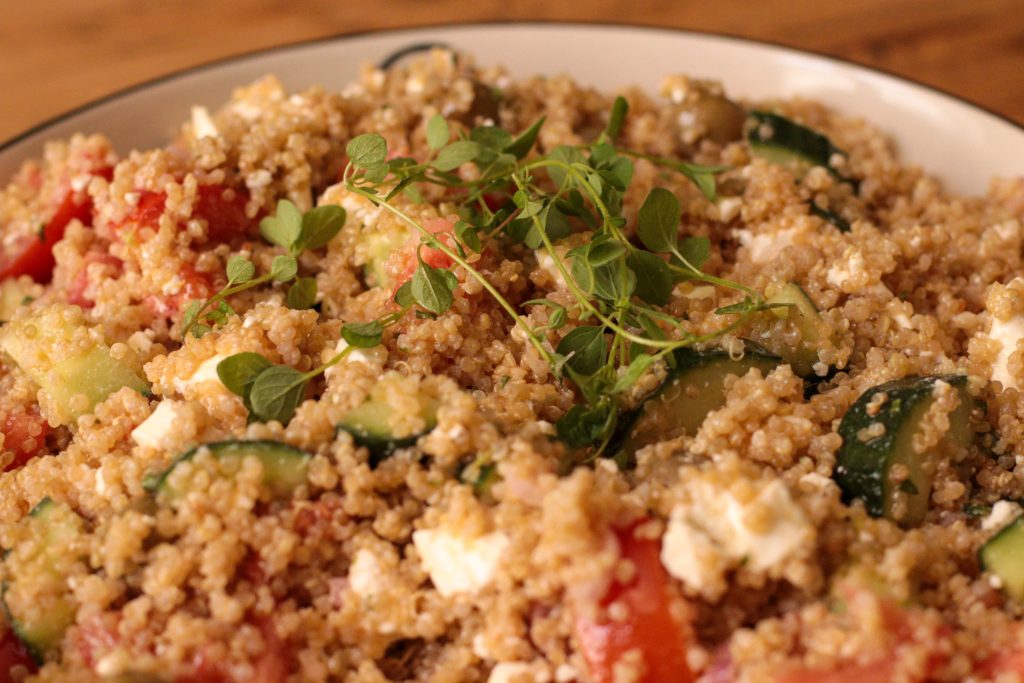 Freshly mixed salad without lettuce made with quinoa, tomato, cucumber, feta, and olive oil dressing