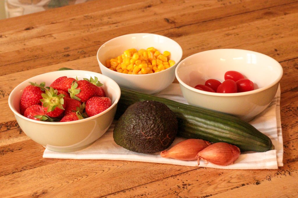 ingredients for quinoa salad recipe on a white cloth on a wooden table
