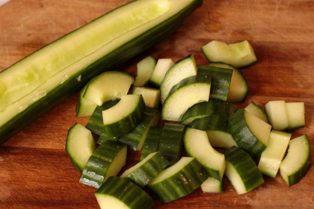 cucumber deseeded and cubed on a wooden board
