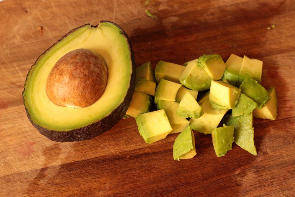 avocado cubed on a wooden board