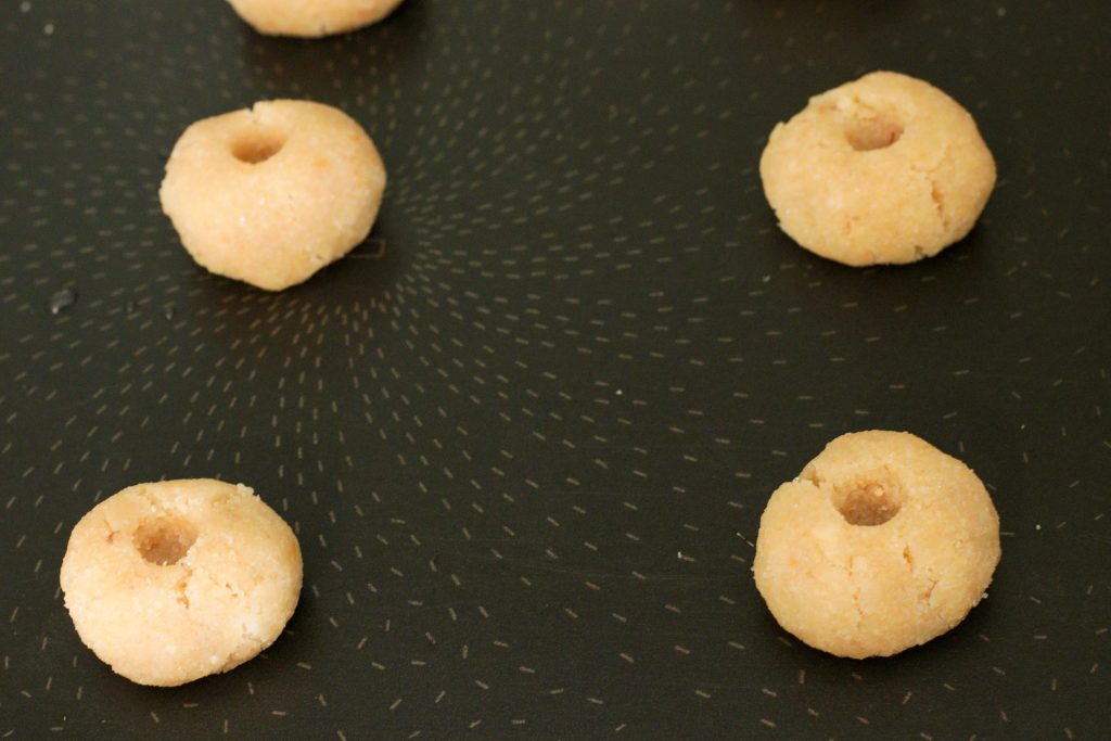 biscuits en forme de pouce avec un trou sur le dessus prêt à être rempli de confiture