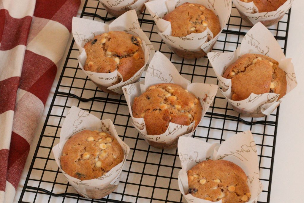 les muffins aux canneberges et au chocolat blanc sur une grille noire