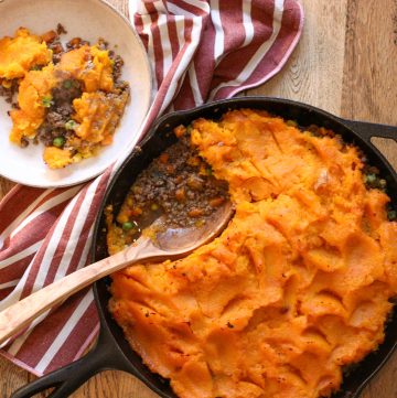 tarte à la courge butternut dans une poêle en fonte, vue d'en haut avec une petite assiette servie