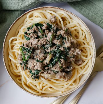 Ground beef stroganoff of a white table with a green tea towel in the background
