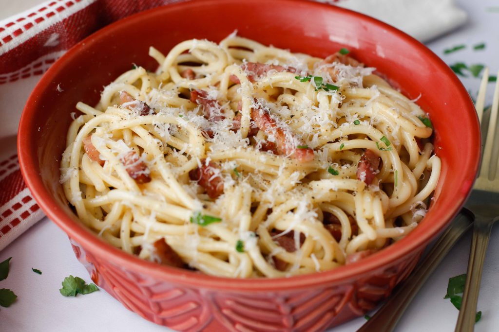 Easy spaghetti carbonara with cream in a red bowl